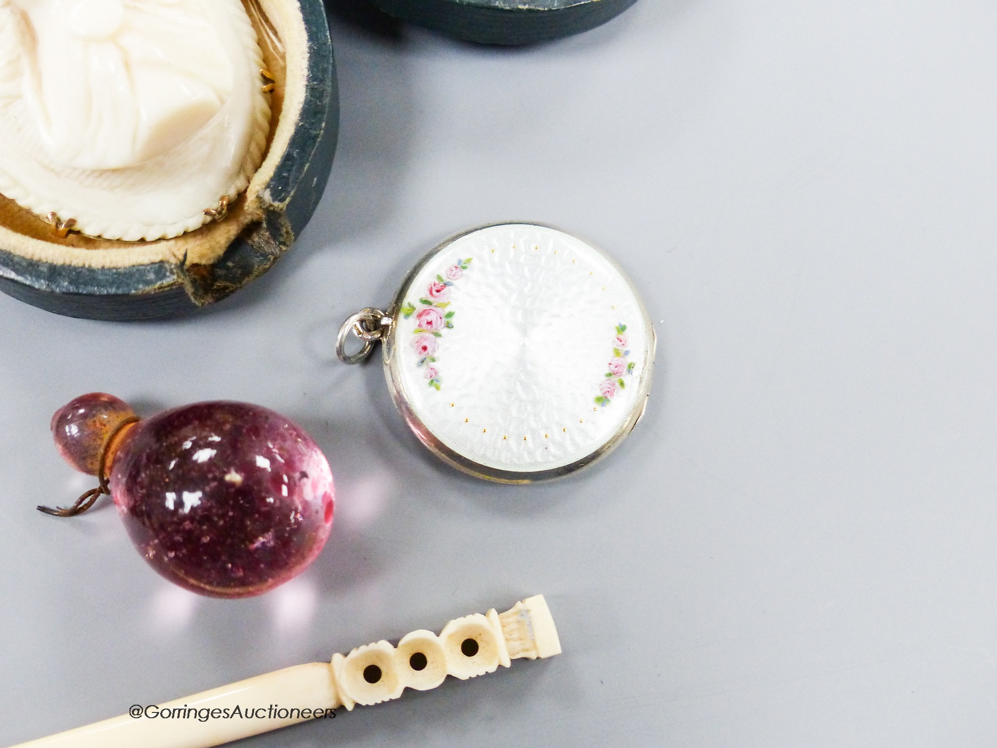 A small group of assorted bijouterie including base metal and composite poodle pin cushion, a white metal and enamel locket on sterling chain, a citrine brooch(lacking pin), a slit pearl set yellow metal mourning clasp e